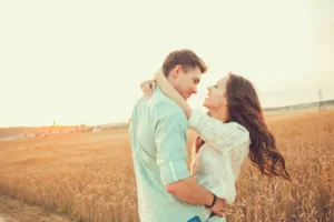 A young couple embrace each other in a cornfield. Masturbation in marriage might be problematic if it sabotages intimacy.