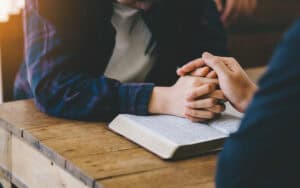 A group of Christians pray near a Bible