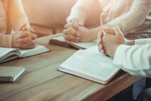 Couples are sitting around a table studying the Bible.