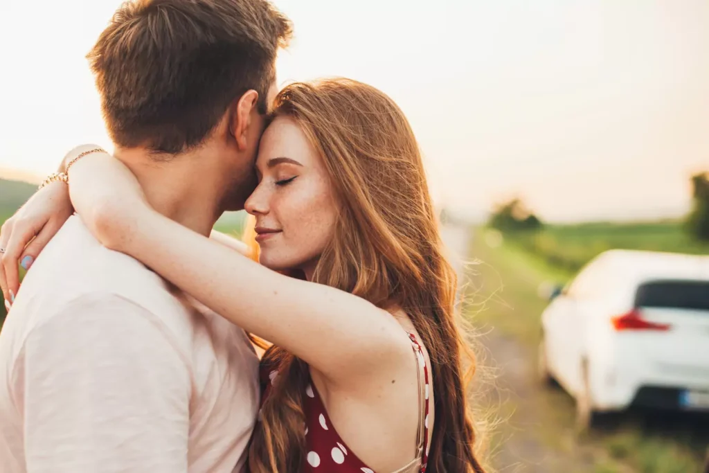 A young couple enjoy a loving embrace in a summertime sunset. You, too, can enjoy emotional intimacy with your spouse if you're willing to invest the time being vulnerable with each other and with God.