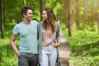 A young couple walk arm-in-arm down a pathway in a park surrounded by trees. How can you fix an unhappy marriage? Learn how you can develop effective, yet simple habits for marital happiness.