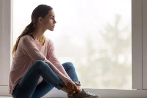 A sad woman sits next to a window, contemplating her insecurities. You may be able to work through insecurity in your relationship by seeking help. Here are some suggestions to get you started.