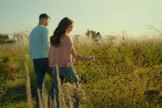 A young couple walks through a field of flowers and tall grass holding hands at sunset. Date night with your spouse makes a difference. Intentional pursuit of my husband is worth the effort. Our marriage is worth it.