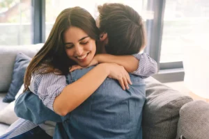 A young wife hugs her husband joyfully, as if thanking him for his encouragement and support. Here are some things you can do to encourage and support your spouse so that they can reach their full potential for God and for good.