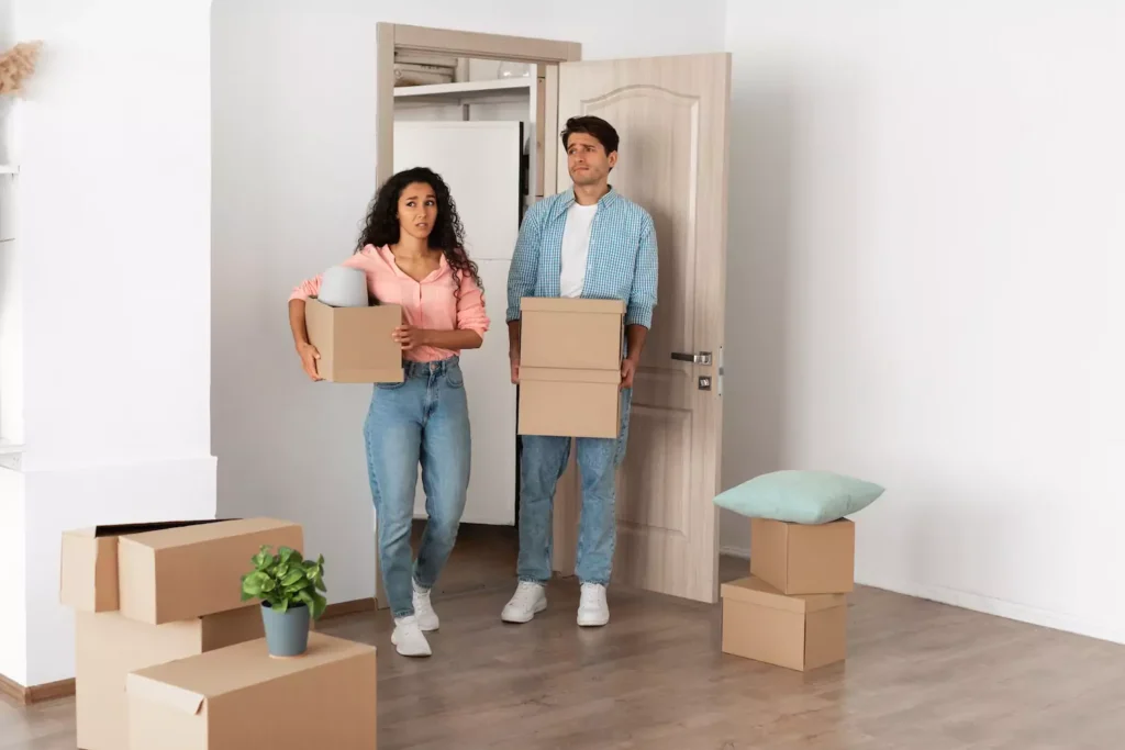 A young couple bring boxes in to an empty apartment. The stand in the doorway with looks of doubt, uncertainty and questioning on their faces. Many people mistakenly believe that living together is an effective way to test a potential marriage. But is cohabitation really a smart move?