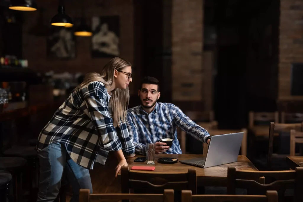 A young wife and husband sit in their dim restaurant after hours, looking at a report of their business that they are running together. Running a business requires humility, wisdom, and compromise. Could marriage partners also be business partners?