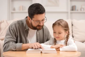 Father teaching child about God from the Bible, leading her to Christ