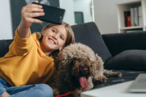 Young girl taking a selfie with her dog.