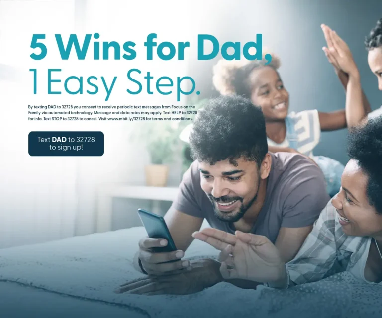 A happy family lying on a bed with a man holding a smartphone, promoting the message '5 Wins for Dad, 1 Easy Step. Text DAD to 32728 to sign up!